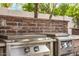 The outdoor grill features stainless steel appliances and a beautiful brick backsplash at 3731 E Halifax Cir, Mesa, AZ 85205