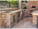 A spacious outdoor kitchen includes stainless steel appliances, a sink, lots of storage and a pizza oven at 3731 E Halifax Cir, Mesa, AZ 85205