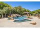 This luxurious pool features a rock waterfall, mature landscaping, and a built-in spa at 3731 E Halifax Cir, Mesa, AZ 85205