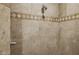 Walk-in shower features decorative tile surround and updated shower head at 3731 E Halifax Cir, Mesa, AZ 85205