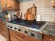 Close up of the Dacor gas range stove and custom wood cabinets at 3731 E Halifax Cir, Mesa, AZ 85205