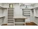 Spacious walk-in closet featuring custom storage and a vanity with a granite countertop at 3731 E Halifax Cir, Mesa, AZ 85205