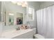 A clean bathroom features a single vanity, neutral walls, and a shower with curtain at 40089 W Bonneau St, Maricopa, AZ 85138