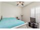 This cozy bedroom features a ceiling fan and plantation shutters for natural light and privacy at 40089 W Bonneau St, Maricopa, AZ 85138