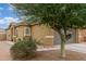 Tan-colored home with a well-kept lawn, desert landscaping, and a spacious two-car garage at 40089 W Bonneau St, Maricopa, AZ 85138