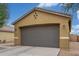 Spacious two-car garage with a gray door, decorative accents, and a paved driveway at 40089 W Bonneau St, Maricopa, AZ 85138