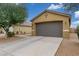Large two-car garage with a paved driveway and desert landscaping surrounding it at 40089 W Bonneau St, Maricopa, AZ 85138