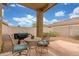 Charming covered patio with wrought iron furniture and a built-in grill, perfect for outdoor dining at 40089 W Bonneau St, Maricopa, AZ 85138