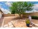 Spacious backyard features desert landscaping, a mature shade tree, and a decorative water feature at 4024 W Griswold Rd, Phoenix, AZ 85051