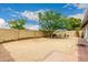 Large backyard with desert landscaping, block wall fence, mature tree, and hardscape patio at 4024 W Griswold Rd, Phoenix, AZ 85051