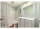 Well-lit bathroom features a vanity with a white countertop and a shower-tub combo with a decorative shower curtain at 4024 W Griswold Rd, Phoenix, AZ 85051