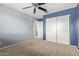 Cozy bedroom with carpet, a ceiling fan and a closet with sliding doors at 41158 W Cahill Dr, Maricopa, AZ 85138