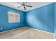 Bedroom with blue walls, neutral carpet, ceiling fan, and window with blinds at 41158 W Cahill Dr, Maricopa, AZ 85138