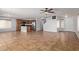 Open-concept living room featuring tile flooring, a kitchen with stainless appliances, and a neutral color palette at 41158 W Cahill Dr, Maricopa, AZ 85138