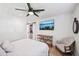 Cozy bedroom with a ceiling fan, comfortable chair, TV, and a barn door leading to a walk-in closet at 4320 N 35Th St, Phoenix, AZ 85018