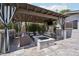 Inviting outdoor living space with travertine tile, a pergola, bar, and a cozy fire pit, perfect for entertaining at 4320 N 35Th St, Phoenix, AZ 85018