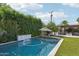Inviting pool and backyard area with lush landscaping, a shade umbrella, and a tranquil waterfall feature at 4320 N 35Th St, Phoenix, AZ 85018