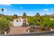 Stunning home showcasing a modern design with a terracotta roof, lush landscaping, and a circular driveway at 4824 E Hummingbird Ln, Paradise Valley, AZ 85253