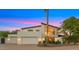 Striking two-story home with a three-car garage and mature landscaping against a colorful dusk sky at 4824 E Hummingbird Ln, Paradise Valley, AZ 85253