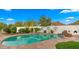 Inviting pool area with stone coping, mature landscaping, and a built-in fireplace, perfect for relaxation at 4824 E Hummingbird Ln, Paradise Valley, AZ 85253