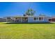 Spacious backyard featuring a covered patio, lush green grass, and mature trees at 6121 N 11Th St, Phoenix, AZ 85014