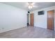 Bright bedroom featuring light wood floors, white walls, a ceiling fan, and a wall-mounted television at 6121 N 11Th St, Phoenix, AZ 85014