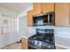 Efficient kitchen includes stainless steel microwave over gas range, white countertops, and door to the side yard at 6121 N 11Th St, Phoenix, AZ 85014