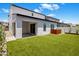 Landscaped backyard with artificial turf, covered patio, and modern metal decor at 6623 E Marisa Ln, Phoenix, AZ 85054