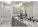A modern bathroom with double sinks, granite countertops, grey cabinetry, and tiled floors with a view to the tub at 6623 E Marisa Ln, Phoenix, AZ 85054