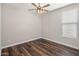 A well-lit bedroom featuring vinyl flooring, neutral walls, a ceiling fan, and a window for natural light at 6623 E Marisa Ln, Phoenix, AZ 85054