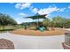 Community playground with slides and swings with walking path surrounded by lush green grass and trees at 6623 E Marisa Ln, Phoenix, AZ 85054
