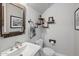 Stylish powder room with a unique mirror and industrial-inspired shelving at 6623 E Marisa Ln, Phoenix, AZ 85054