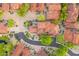 Aerial view of luxury homes featuring private driveways, tiled roofs, well-manicured landscaping, and tranquil pond at 7751 E Golden Eagle Cir, Gold Canyon, AZ 85118