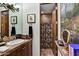 Bathroom with terra cotta tile and a vanity, plus a decorative mirror and a walk-in shower at 7751 E Golden Eagle Cir, Gold Canyon, AZ 85118