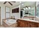 Bathroom featuring a soaking tub with marble surround, as well as double sinks and shuttered windows at 7751 E Golden Eagle Cir, Gold Canyon, AZ 85118