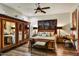 Bedroom featuring dark wood floors, ceiling fan, and shuttered windows, plus a large decorative wardrobe at 7751 E Golden Eagle Cir, Gold Canyon, AZ 85118
