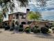 Beautiful exterior of a two-story home with stone accents, a balcony and a landscaped yard at 7751 E Golden Eagle Cir, Gold Canyon, AZ 85118