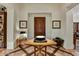 Beautiful foyer featuring a decorative table, artwork, sconce lighting and wooden door for a welcoming entrance at 7751 E Golden Eagle Cir, Gold Canyon, AZ 85118