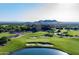 Beautiful aerial view of a lush green golf course with pond and mountain views at 7751 E Golden Eagle Cir, Gold Canyon, AZ 85118