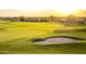 Scenic golf course featuring a sand trap and well-manicured green under a sunset sky at 7751 E Golden Eagle Cir, Gold Canyon, AZ 85118