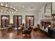 Elegant living room with fireplace, hardwood floors, chandelier, and French doors for a luxurious feel at 7751 E Golden Eagle Cir, Gold Canyon, AZ 85118