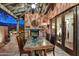 Inviting patio with a fireplace, marble table, and doors that lead to the interior of the home at 7751 E Golden Eagle Cir, Gold Canyon, AZ 85118