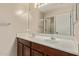 Bathroom vanity with double sinks, framed mirror, and wood cabinets at 7812 S 67Th Ln, Laveen, AZ 85339