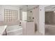 Bathroom featuring tiled walk-in shower, soaking tub, and a glass block window at 7812 S 67Th Ln, Laveen, AZ 85339