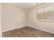 Small bedroom with hardwood floors and a window with blinds at 7812 S 67Th Ln, Laveen, AZ 85339