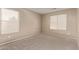 Neutral bedroom with two windows providing natural light, and plush carpet at 7812 S 67Th Ln, Laveen, AZ 85339