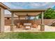 Relaxing covered patio with comfortable seating, stone pillars, and a ceiling fan, ideal for outdoor gatherings at 7812 S 67Th Ln, Laveen, AZ 85339