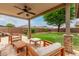 Inviting covered patio with stone accents and a ceiling fan overlooks the lush backyard, perfect for outdoor entertaining at 7812 S 67Th Ln, Laveen, AZ 85339
