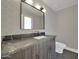 Bathroom with patterned wallpaper, granite countertop, and dark wood vanity at 8525 E Vía De Los Libros --, Scottsdale, AZ 85258
