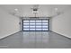 A spacious, well-lit garage featuring a modern glass panel garage door and sealed concrete flooring at 8525 E Vía De Los Libros --, Scottsdale, AZ 85258